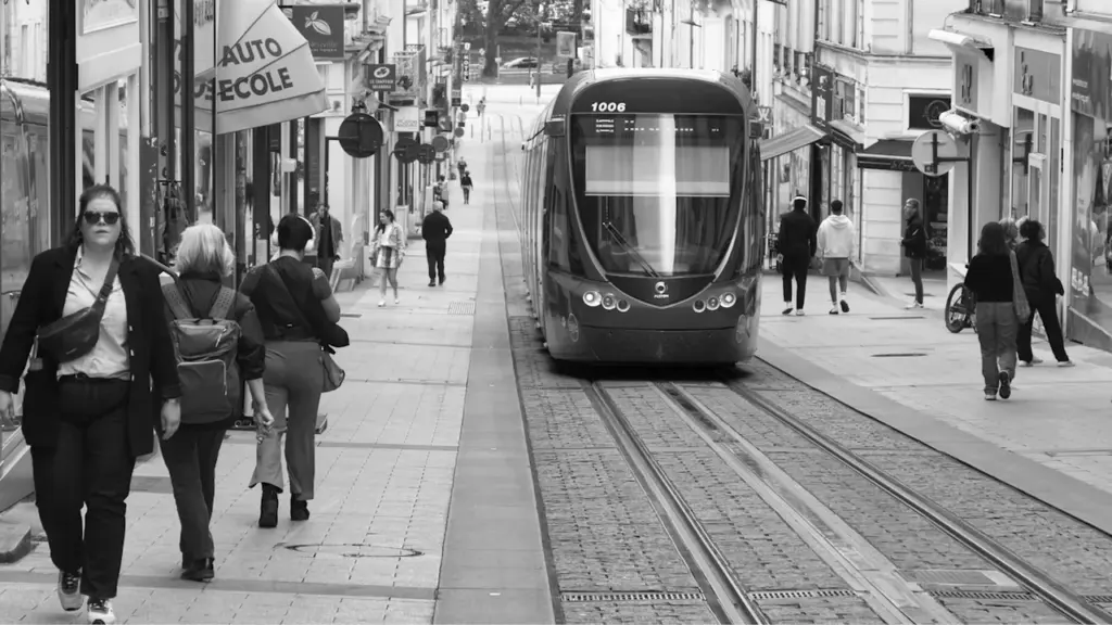 Tramway circulant dans une rue urbaine animée du centre-ville d'Angers.