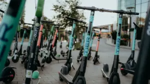 Plusieurs trottinettes électriques en libre-service stationnées sur un trottoir urbain.