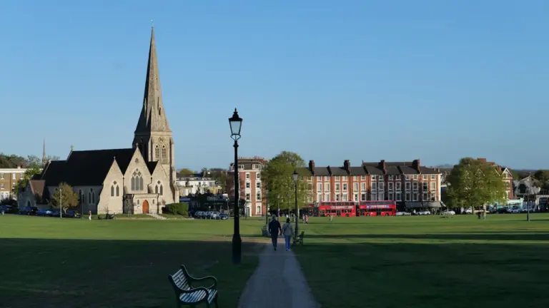 Une église historique surplombant un parc urbain avec une allée pavée.