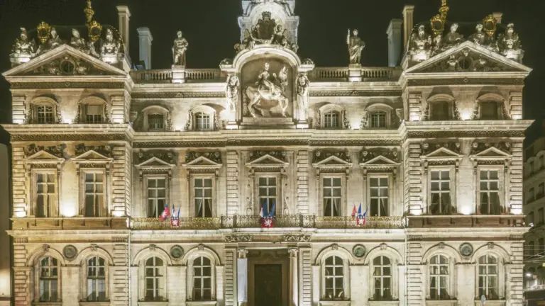 Façade de l'Hôtel de Ville de Lyon illuminée dans la nuit lyonnaise.