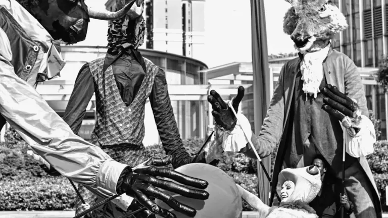 Artistes en costumes de spectacle avec des marionnettes géantes lors d'un festival français.