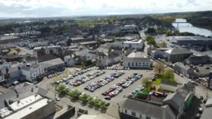 Vue aérienne d'un parking urbain dense entouré de bâtiments en centre-ville.