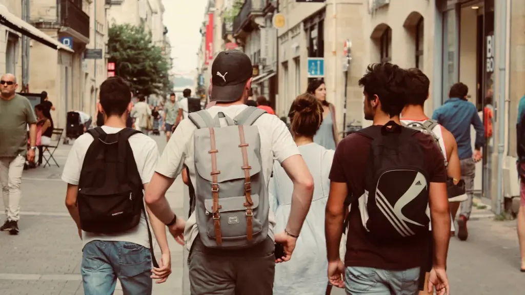 Groupe de jeunes gens marchant dans une rue commerçante en centre-ville.