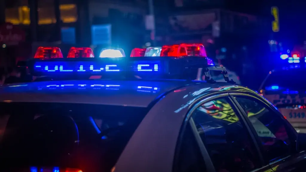 Gros plan sur les gyrophares bleus d'une voiture de police la nuit