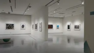 Galerie d'art moderne spacieuse avec des cadres élégants accrochés aux murs blancs.