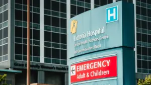 Panneau de signalisation des urgences de l'hôpital Victoria sur fond de bâtiment moderne.