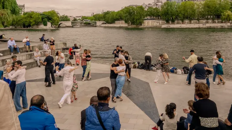 Des personnes dansant en plein air le long de la Seine à Paris.