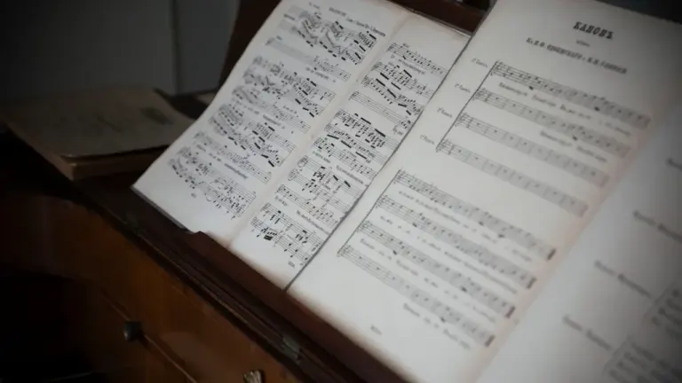 Partition de musique classique posée sur un ancien piano en bois sombre.