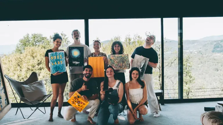 Un groupe d'amis présente fièrement leurs créations artistiques dans un espace lumineux à Grenoble.