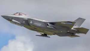 Un avion de chasse F-35 en plein vol sous un ciel nuageux.