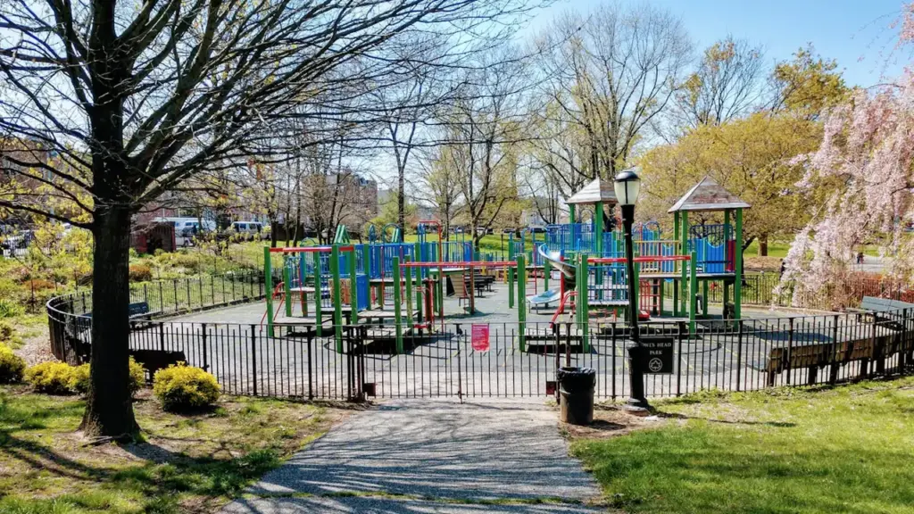 Aire de jeux publique dans un parc urbain avec des structures de jeux modernes.