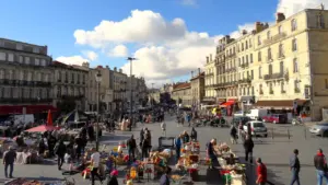 Vue panoramique d'un marché en plein air avec des stands et des visiteurs.