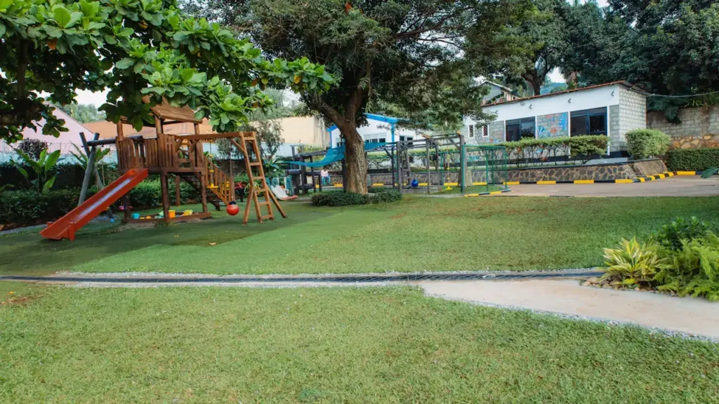 Une aire de jeux avec un toboggan et des balançoires dans un espace vert.