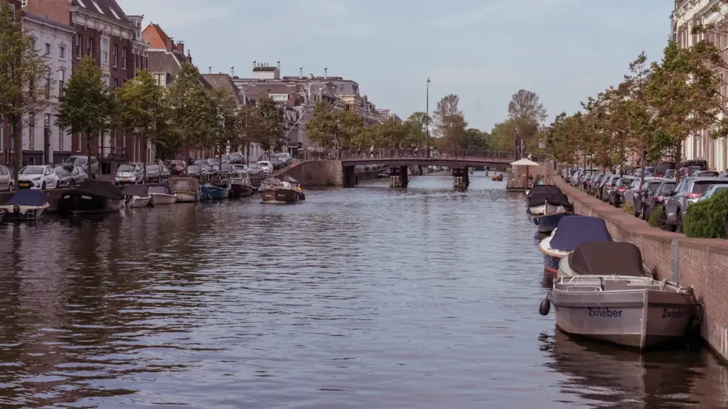 Vue paisible d'un canal bordé de maisons traditionnelles et de bateaux amarrés.