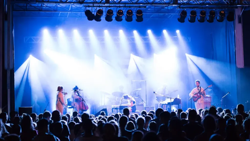 Un groupe de musiciens se produit sur une scène éclairée lors d'un festival.