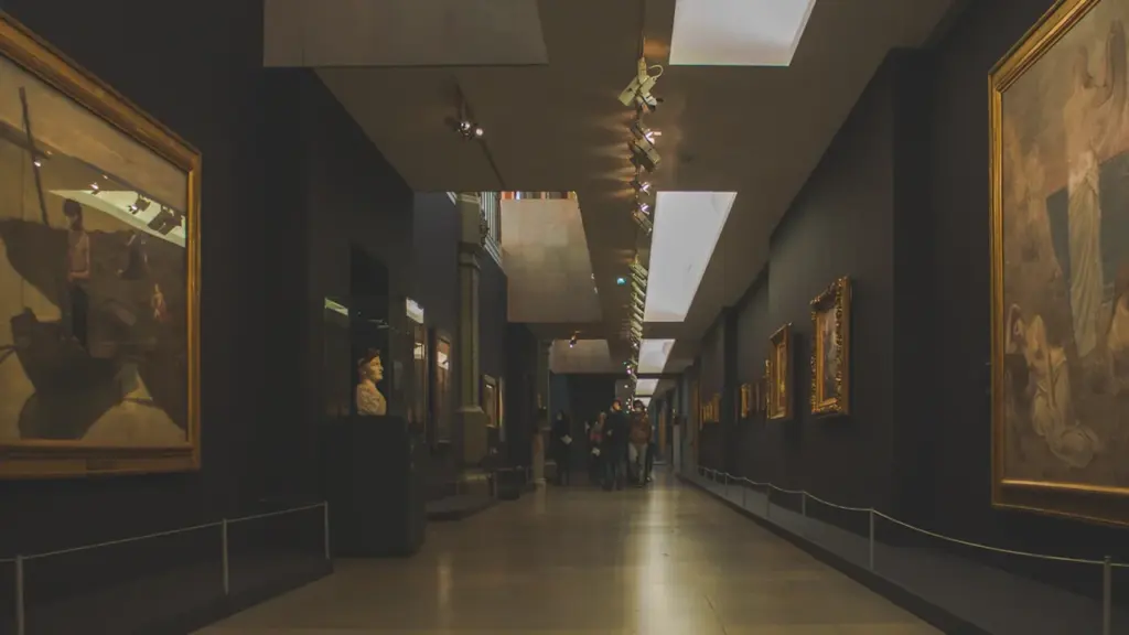 Une longue galerie de musée avec des peintures exposées sur les murs