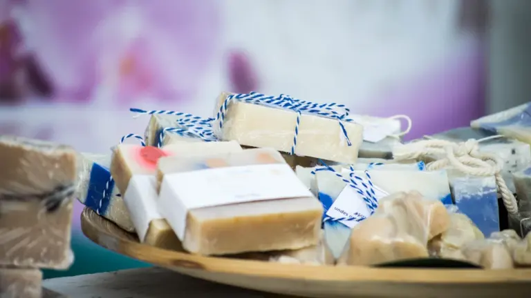 Savons artisanaux emballés dans du papier kraft sur une table en bois rustique.