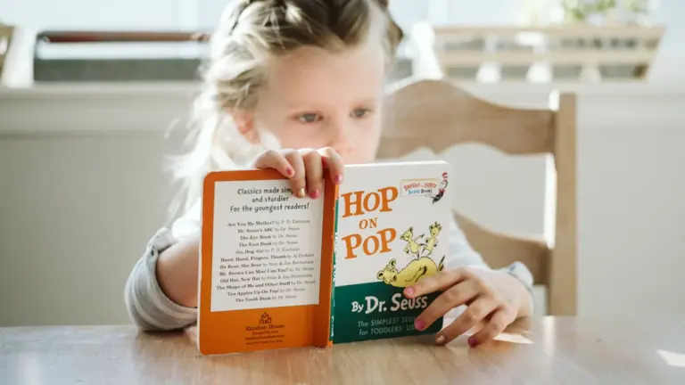 Une jeune fille concentrée lisant un livre dans un environnement calme et lumineux.