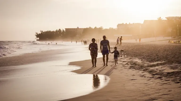 Silhouettes de familles marchant sur la plage au coucher du soleil à Trouville.