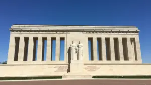 Façade architecturale en pierre blanche sous un ciel bleu dégagé.
