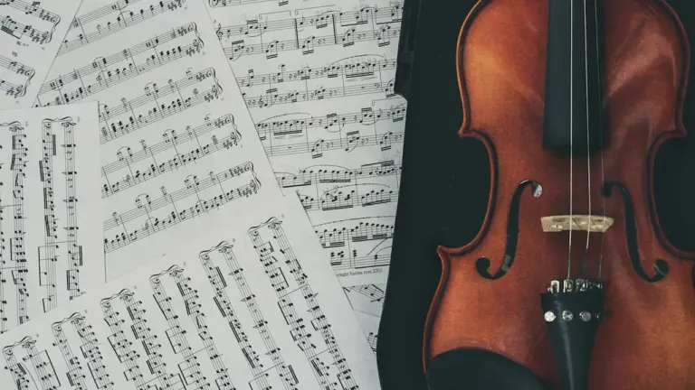 Un violon posé sur des partitions de musique classique pour un concert.