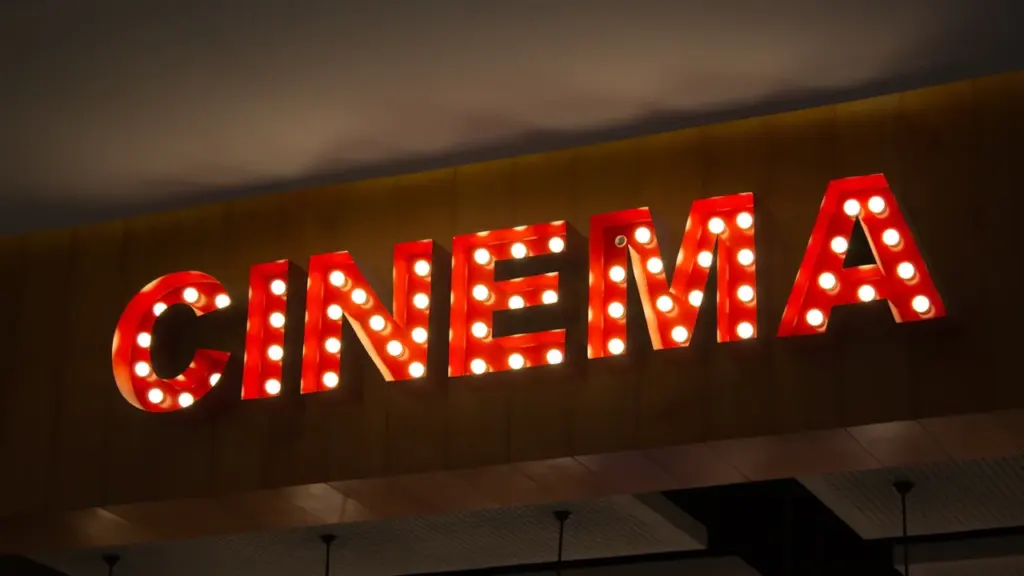 Enseigne lumineuse rouge affichant le mot CINEMA dans un style rétro et élégant.