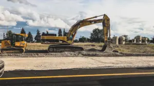 Pelleteuse jaune sur un chantier routier en cours de travaux à Versailles.