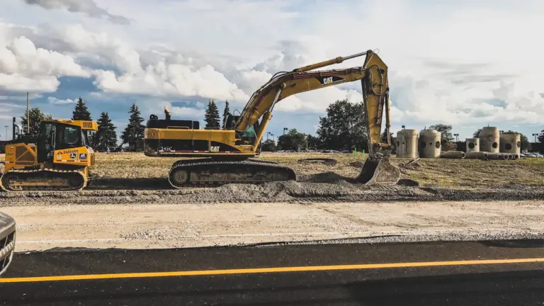 Pelleteuse jaune sur un chantier routier en cours de travaux à Versailles.