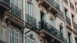 Façade d'un immeuble classique avec balcons en fer forgé typique en France.
