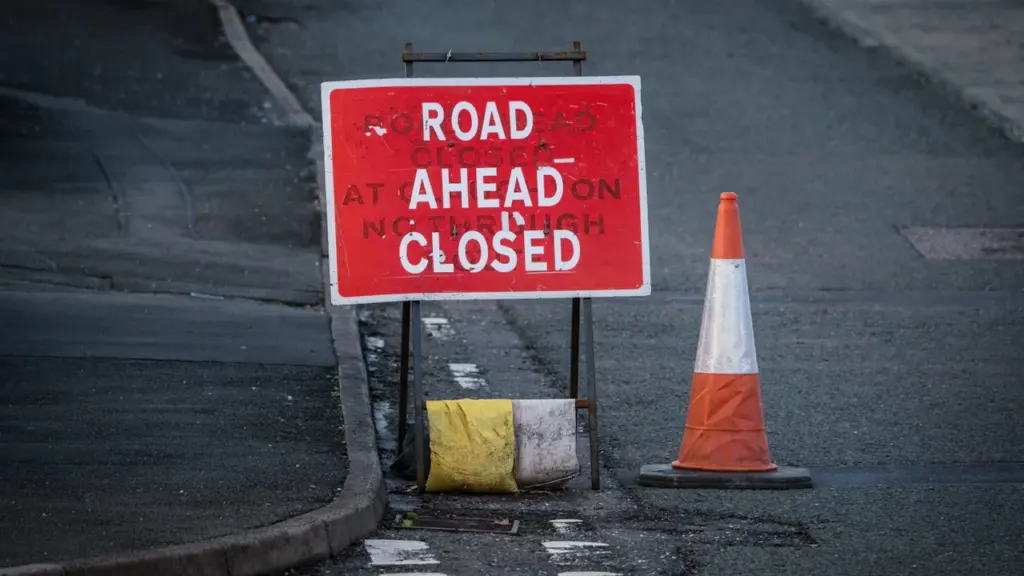 Panneau de signalisation routière indiquant une route fermée avec un cône de chantier.