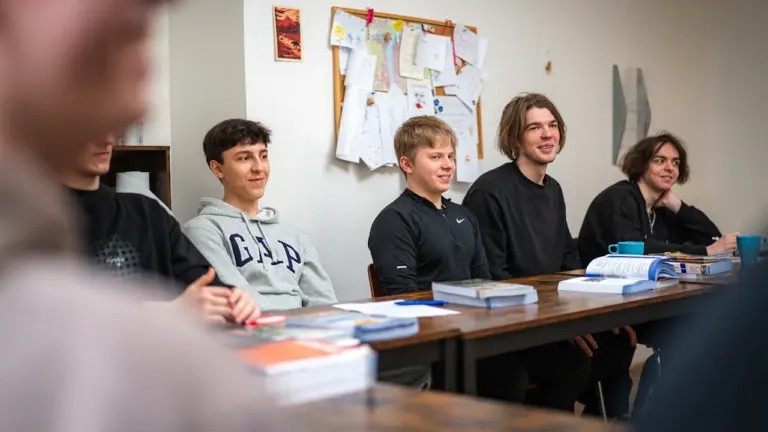 Un groupe de jeunes étudiants assis à une table dans une salle de réunion.