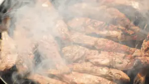 Viandes assaisonnées en train de griller sur un barbecue fumant