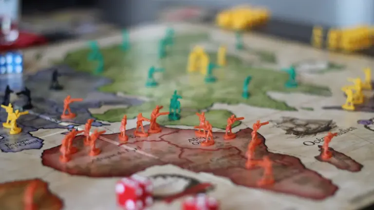 Plateau de jeu de stratégie avec des figurines et une carte géographique.