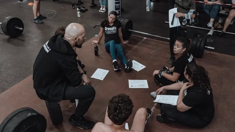 Un groupe de jeunes en formation assis dans une salle de sport.