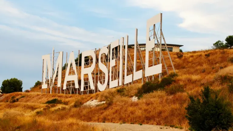 Le panneau monumental affichant le nom Marseille sur une colline ensoleillée.
