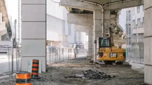 Engin de chantier jaune sur un site de construction de pont en ville.